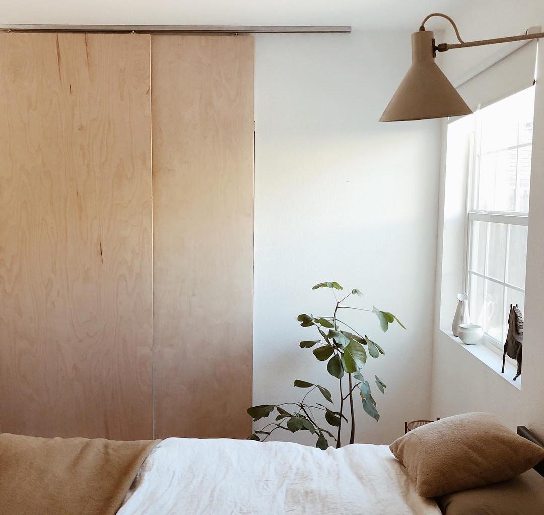 warm minimalist bedroom with japanse plywood closet doors