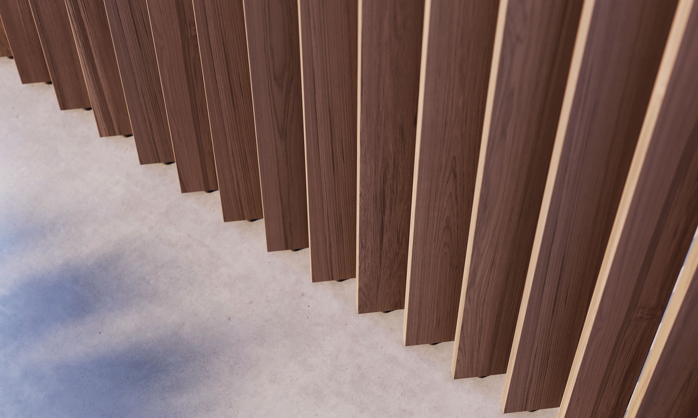 Close-up of vertical wooden wall panels against a smooth concrete floor, showcasing the blend of wooden and concrete textures.