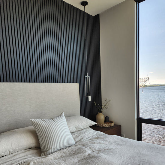 modern monochromatic lakefront condo bedroom with black wood slat accent wall
