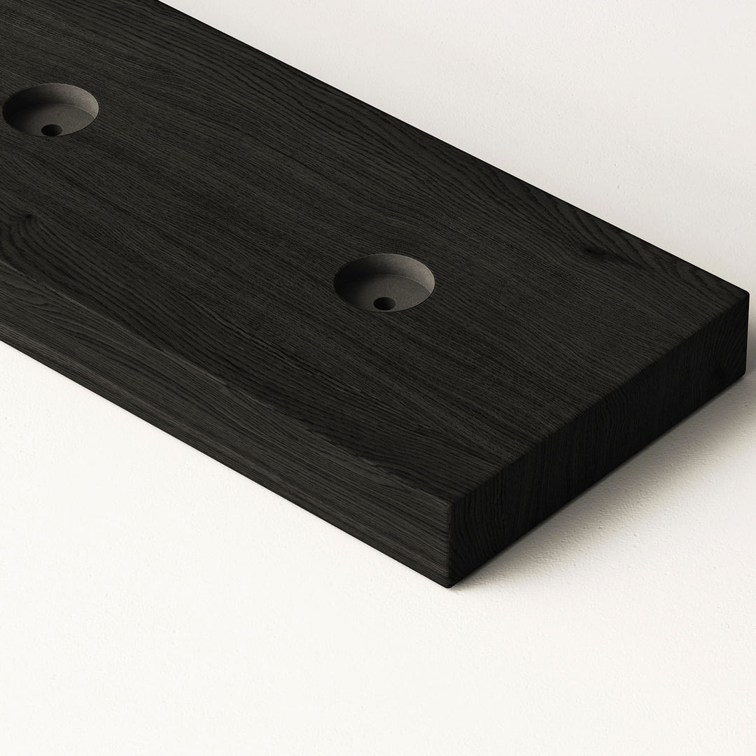closeup image of wood slat divider floor base with pre-drilled holes in black oak