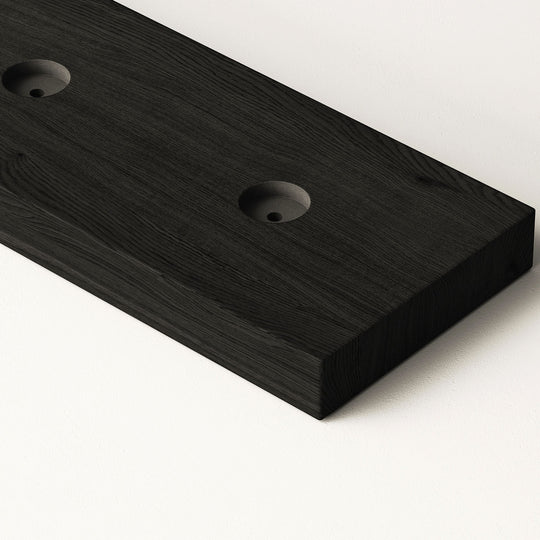 closeup image of wood slat divider floor base with pre-drilled holes in black oak