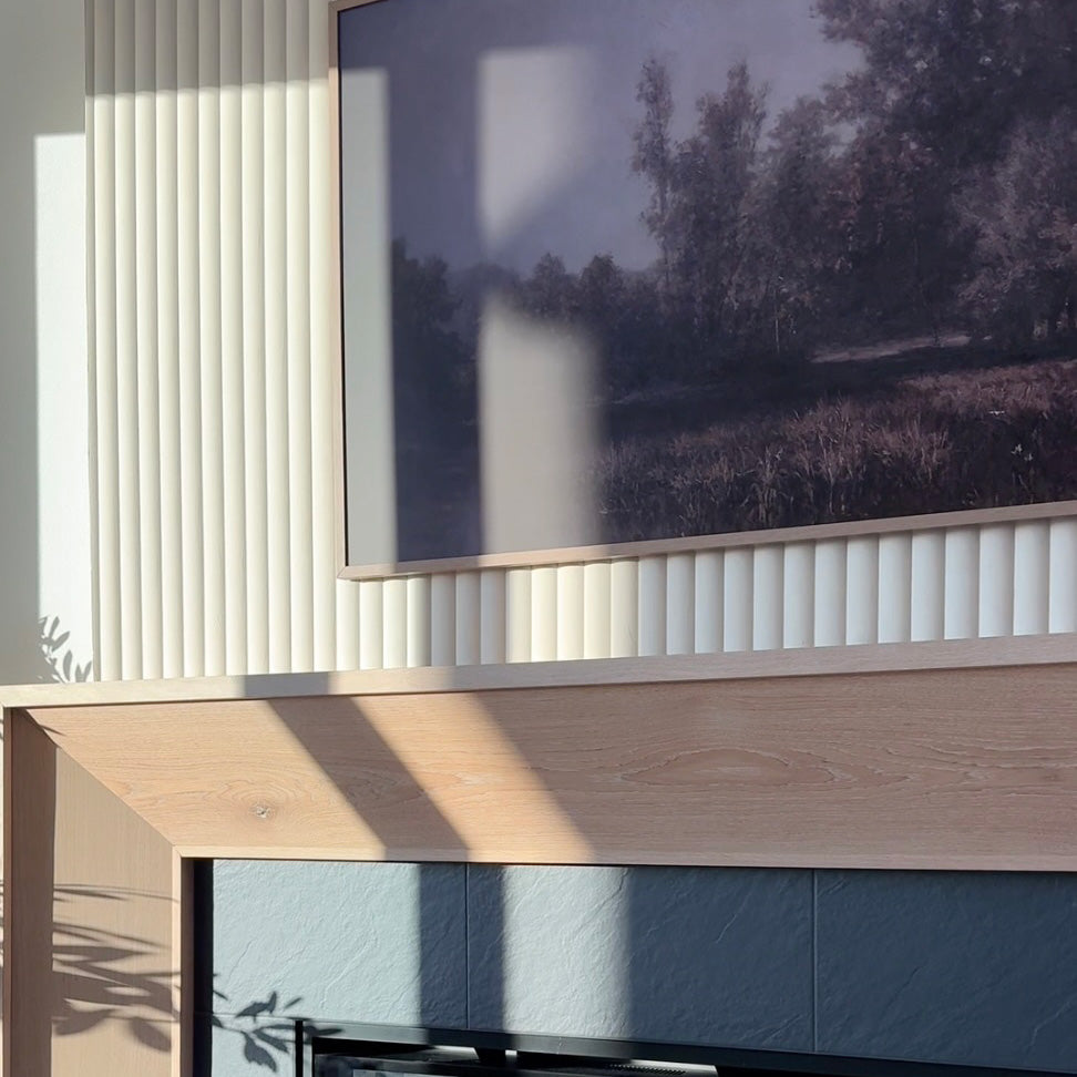 closeup image of white oak fireplace mantle with white ribbed wall paneling above it