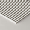 A close-up of a paintable tambour panel shown at an angle on a light gray surface.