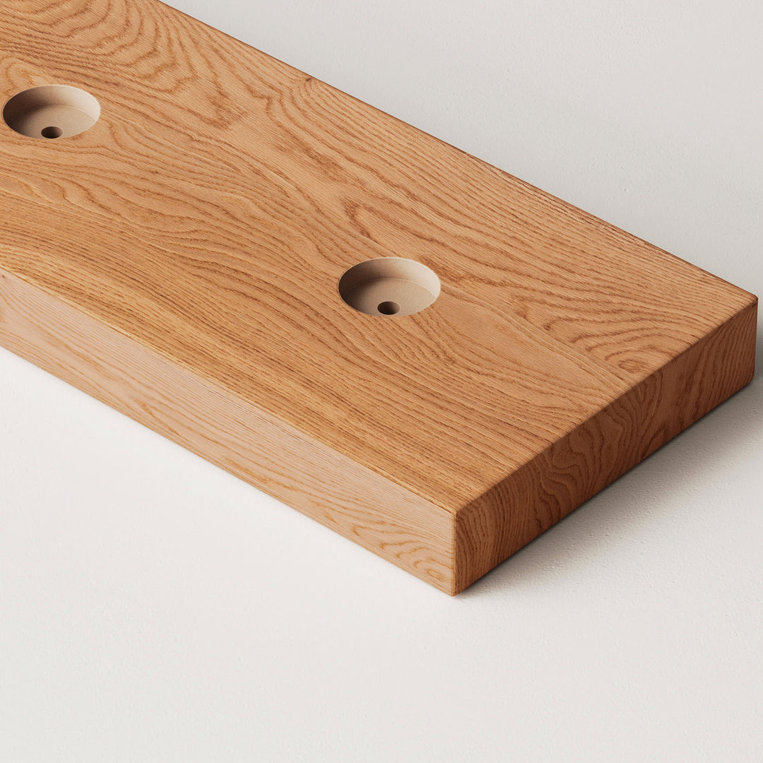 closeup image of wood slat divider floor base with pre-drilled holes in golden oak