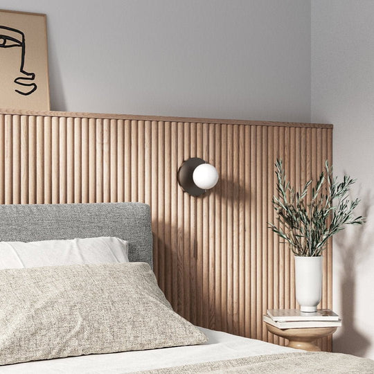 scandinavian bedroom with linen bedding and a half-wall accent in fluted white oak panelling