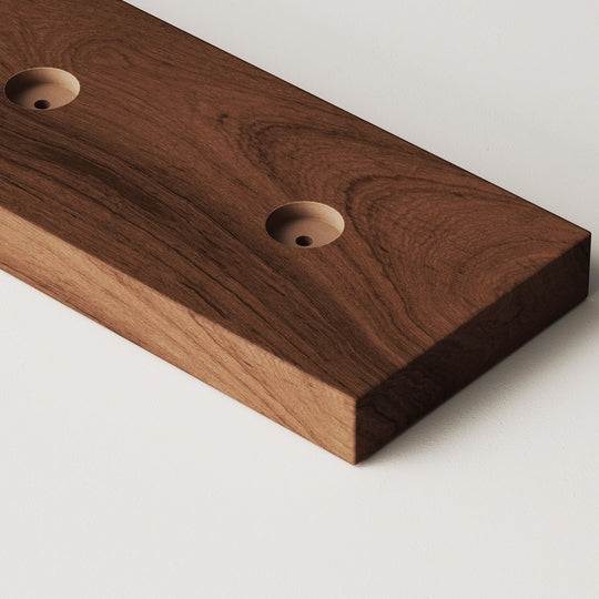 closeup image of wood slat divider floor base with pre-drilled holes in walnut